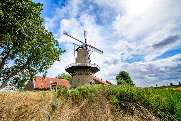 The Hompesche Mill on a cloudy summer day with a gentleman taking a photo of the mill