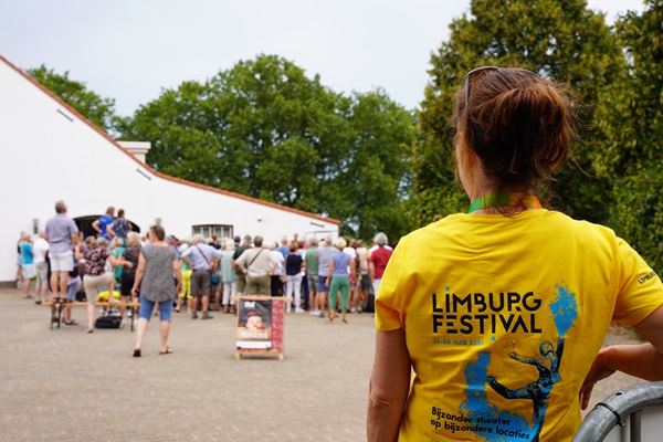 Medewerker van het Limburg festival kijkt toe hoe toeschouwers aan het kijken zijn naar een van de vele acts.